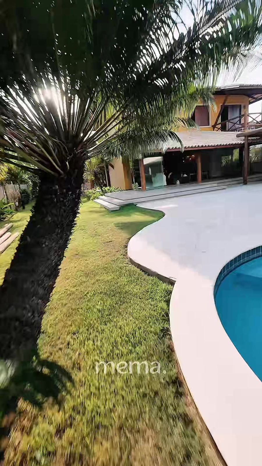 Fachada da casa com jardim tropical e piscina